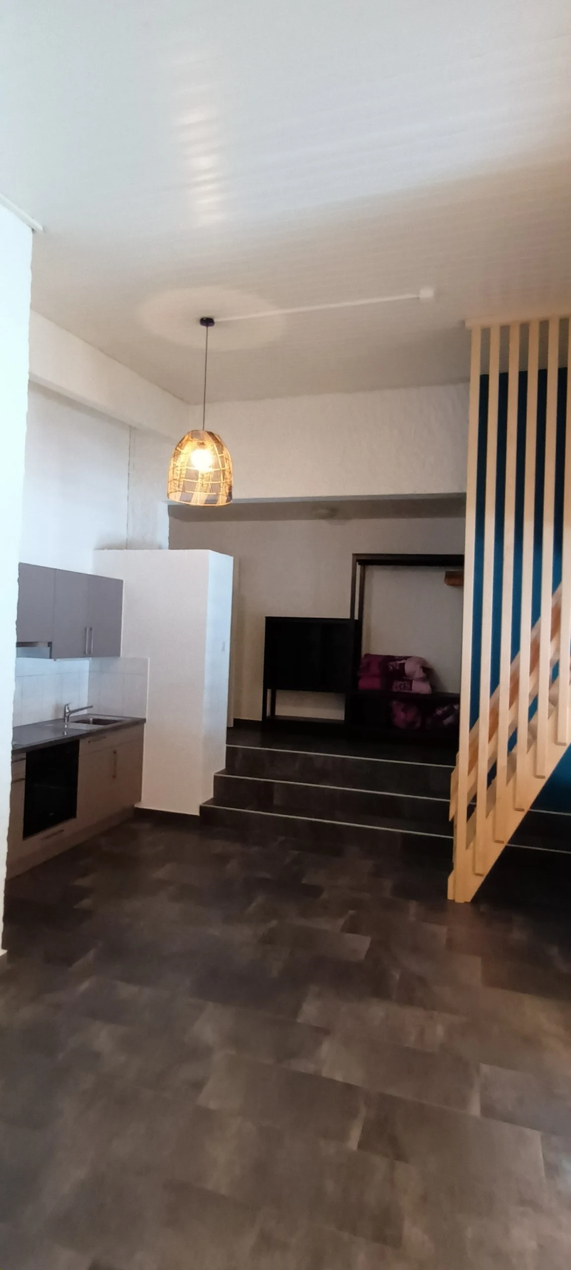 Cuisine équipée et escalier vers la mezzanine du studio